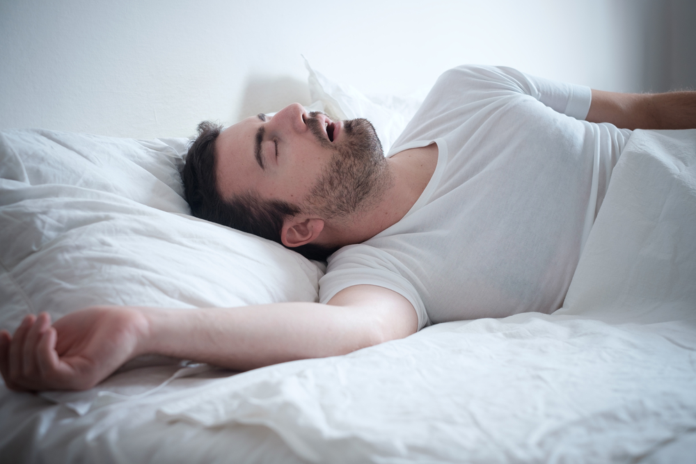 Man sleeping in his bed and snoring loudly.