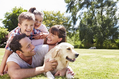 family embracing with their dog.